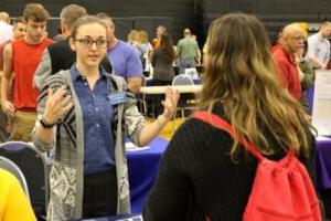 college recruiter standing at table talking to guest